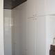 Stanza guardaroba con armadiatura laccata bianco lucido e controsoffittatura in legno wengé