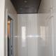 Stanza guardaroba con armadiatura laccata bianco lucido e controsoffittatura in legno wengé